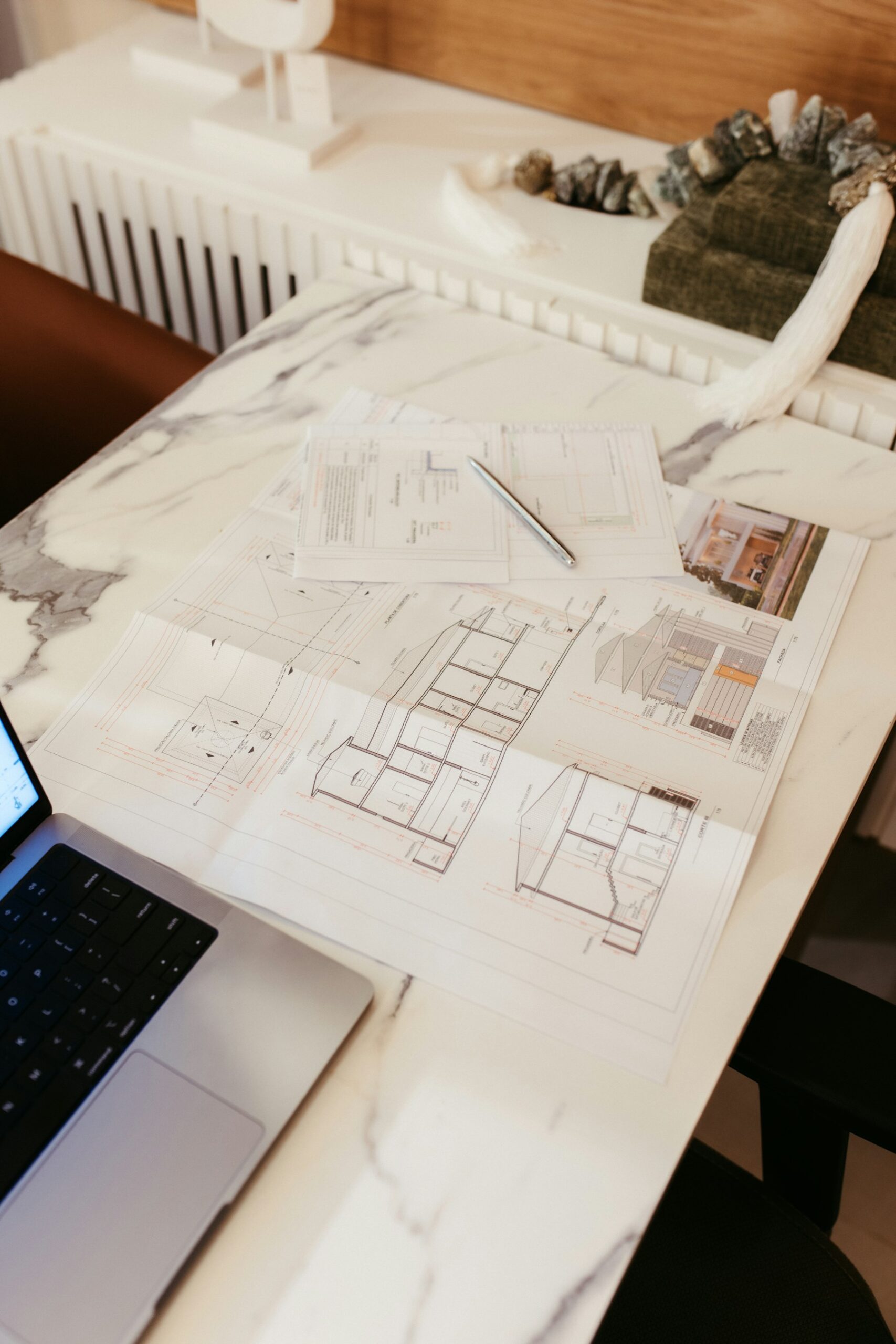 Tekniska ritningar och projekteringsunderlag på ett skrivbord